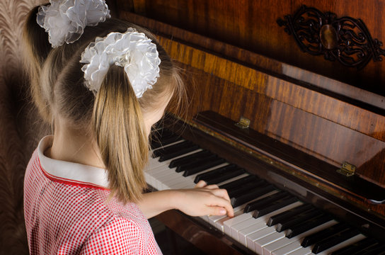 girl learns to play a piano