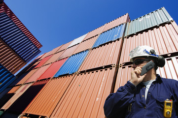 poert worker with stacks of cargo containers