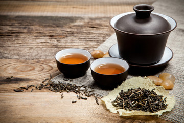 Tea cups with teapot on old wooden table