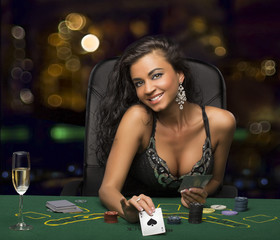brunette girl in the casino playing poker, shows a playing card