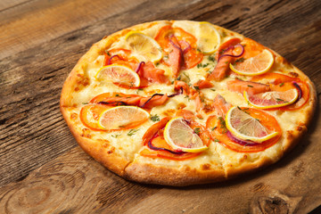 Salmone pizza on wooden table.