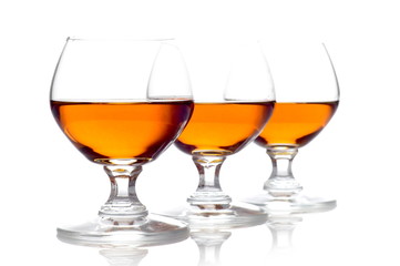Three glasses of cognac isolated on white