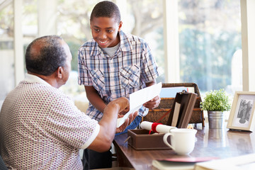 Grandfather Showing Document To Grandson
