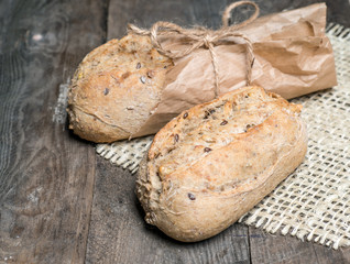 Hot and crunchy freshly baked cob of bread on old wooden table