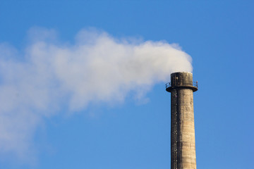 Industrial smoke chimney on blue sky