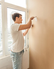 man aligning holes from dowel on gypsum cardboard