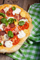 Pizza with salami, tomato and ham