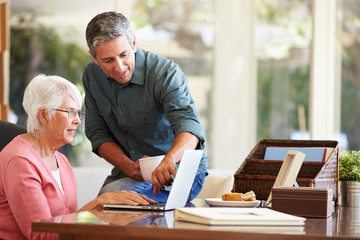 Adult Son Helping Mother With Laptop