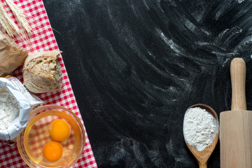 Flour, eggs, and cooking utensils on a wooden cutting board