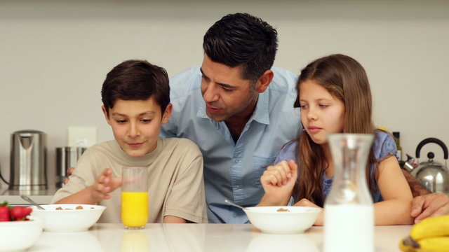 Father chatting with his children having breakfast