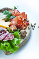 Italian cuisine. Prosciutto, cheese, salami, herbs.