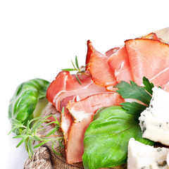 Sliced prosciutto with salami,cheese and basil on a wooden board