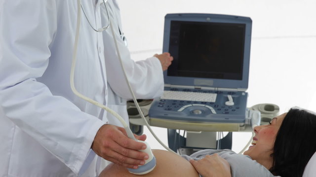 Brunette pregnant woman having a sonogram scan