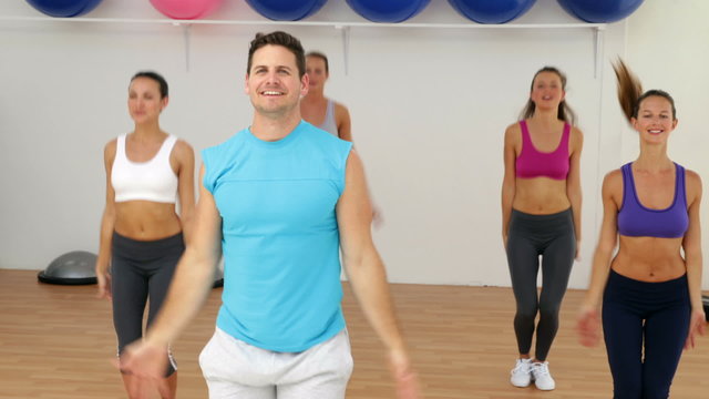 Aerobics instructor leading a happy class of women