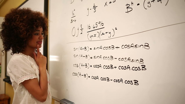 Confused student looking at maths on whiteboard