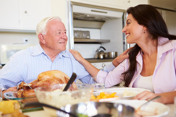 Father And Adult Daughter Having Family Meal At Table