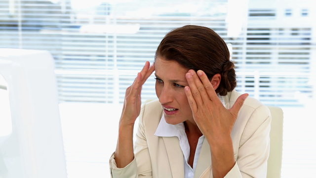 Businesswoman getting stressed at her desk