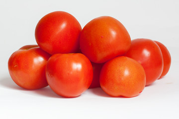 Tomates en tas sur fond blanc