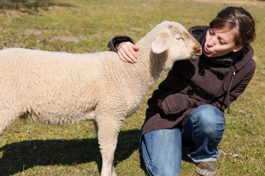 junge Frau küsst kleines Lamm