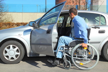 Fototapeta na wymiar Rollstuhlfahrer beim Einsteigen in Auto 2
