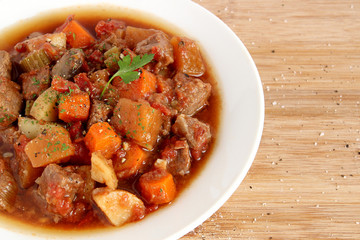 Beef stew in white plate, close-up view