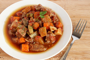 Beef stew in white plate, close-up view