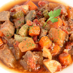 Beef stew in white plate, close-up view
