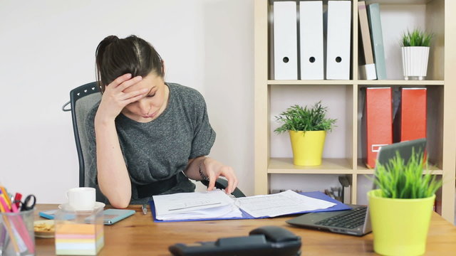 Sad, overwhelmed businesswoman with too much work in office