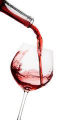 Red wine poured in a glass isolated on white