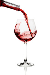 Red wine poured in a glass isolated on white