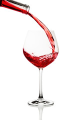 Red wine poured in a glass isolated on white