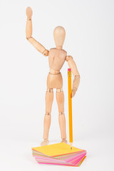 Small wood mannequin stand writing with colour pencil isolated o