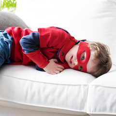 Little superhero resting on sofa © stokkete