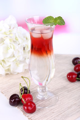 Glass of cocktail on table on light background