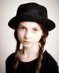 Blue eyed girl with plaits and hat