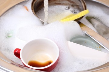 Utensils soaking in kitchen sink