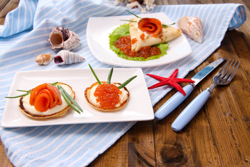 Pancakes with red caviar, salmon and mayo, green onion,