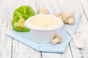 Delicate mushroom sauce in bowl on wooden table close-up