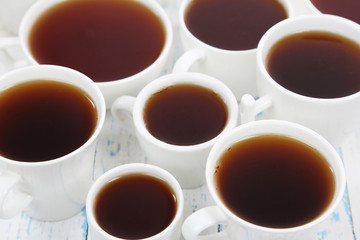 Many cups of tea on table close-up