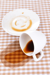 Overturned cup of coffee on table close-up