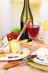 Assorted cheese plate , grape and wine glass