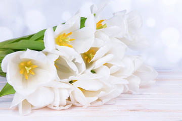 Obraz na płótnie Canvas Beautiful bouquet of white tulips on table on light background