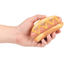 Hand holds hotdog with mustard.
