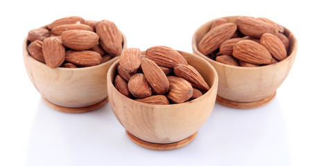Almond in wooden bowls, isolated on white