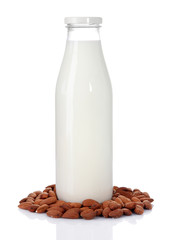 Almond milk in bottle with almonds, isolated on white