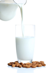 Almond milk is poured into glass, isolated on white