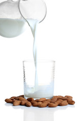 Almond milk is poured into glass, isolated on white