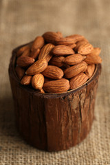 Almonds in bowl on sackcloth background