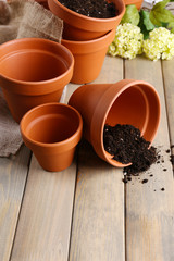Clay flower pots and soil, on wooden table