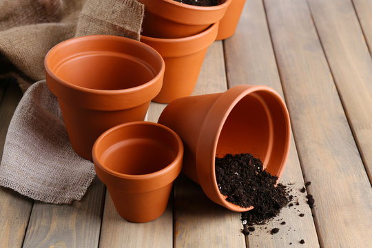 Fototapeta Clay flower pots and soil, on wooden table